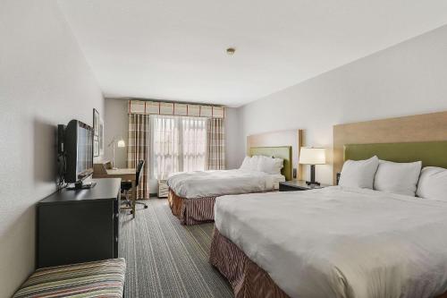 Country Inn & Suites by Radisson, Green Bay, WI في اشوبينون: غرفة فندقية بسريرين وتلفزيون بشاشة مسطحة