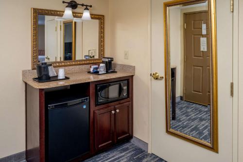 Country Inn & Suites by Radisson, Princeton, WV في برنستون: حمام مع حوض ومرآة