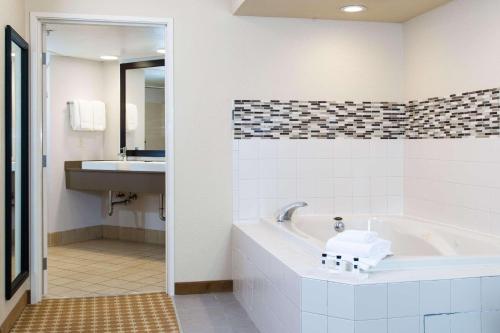uma casa de banho com uma banheira e um lavatório em Country Inn & Suites by Radisson, Milwaukee West Brookfield , WI em Brookfield