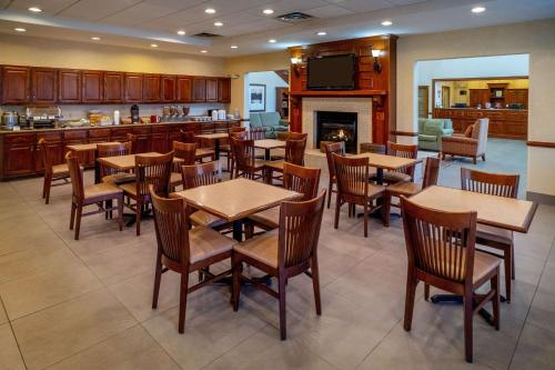 Country Inn & Suites by Radisson, Princeton, WV في برنستون: مطعم بطاولات وكراسي ومدفأة