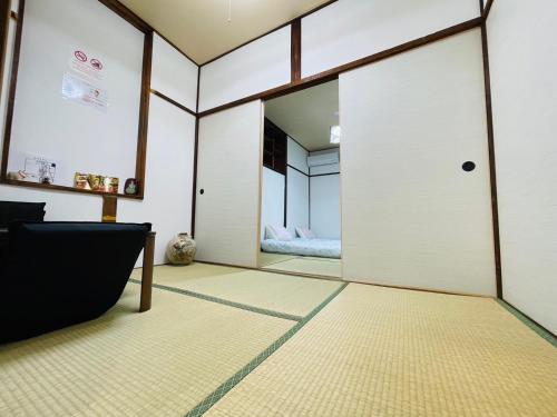a room with a sliding door and a bedroom at 難波心斎橋10minutes民宿2号室 in Osaka