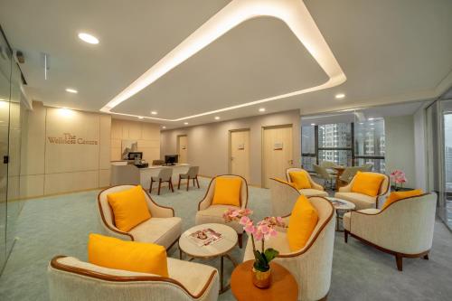 a waiting room with orange chairs and a table at Sunway Sanctuary - Seniors Hotel & Residences in Subang Jaya