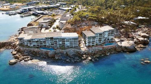 an aerial view of a resort on a rocky island in the water at Beachfront - Nelly Bay Apartment in Nelly Bay