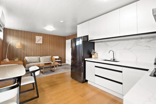 a kitchen with a refrigerator and a living room at The Headley Loft in Queenstown