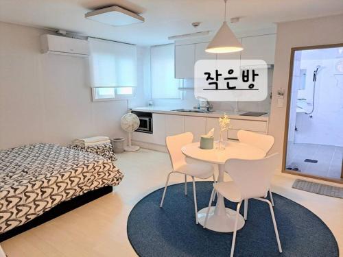 Habitación con cama, mesa y sillas. en Narae House, en Busan