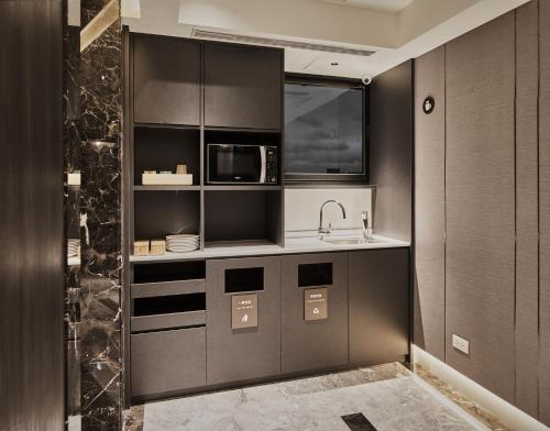 a kitchen with a sink and a microwave at Orange Hotel -Hanzhong, Taipei in Taipei