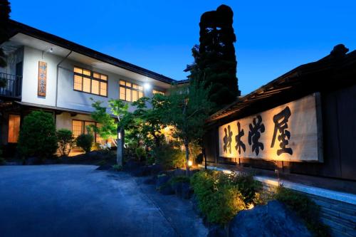 ein Gebäude, in dem nachts geschrieben wird in der Unterkunft ステイインホテル材木栄屋 in Kaminoyama