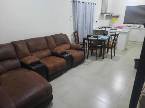 - un salon avec un canapé brun et une table dans l'établissement Salamanca Residencial, à Hermosillo