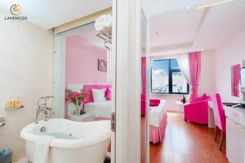 un bagno con vasca e una camera con letto di Lavencos Hotel Da Nang a Da Nang