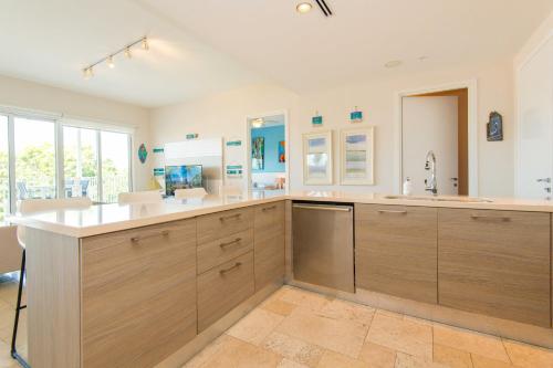 a large kitchen with wooden cabinets and a sink at Elegancia y Relajación en Puntarena Beach Town, Buenaventura in Coclé