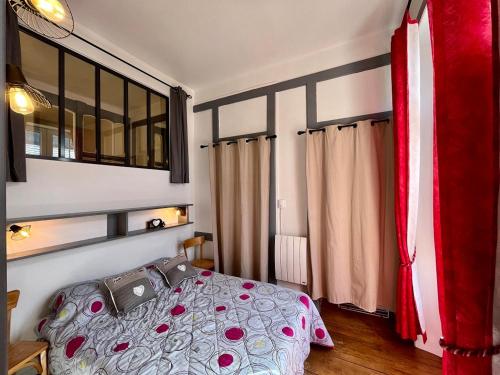 une chambre avec un lit et une grande fenêtre dans l'établissement Charmant T2 au cœur du Mont-Dore, idéal pour 4 pers, face aux thermes, animaux acceptés - FR-1-608-259, à Le Mont-Dore