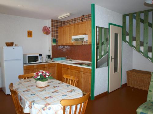 une petite cuisine avec une table et un réfrigérateur dans l'établissement Vacances à Saint-Jean-de-Monts : Pavillon intime 6 pers., proche plage et commerces - FR-1-323-369, à Saint-Jean-de-Monts