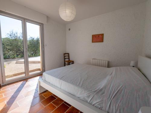 um quarto com uma cama e uma grande janela em Maison Le Lavandou, 5 pièces, 7 personnes - FR-1-677-45 em Le Lavandou