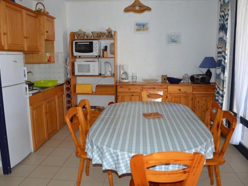 une cuisine avec une table et un réfrigérateur blanc dans l'établissement Maison familiale à deux pas de la plage, idéale pour 6 pers. avec terrasse à Saint Jean de Monts - FR-1-323-480, à Saint-Jean-de-Monts