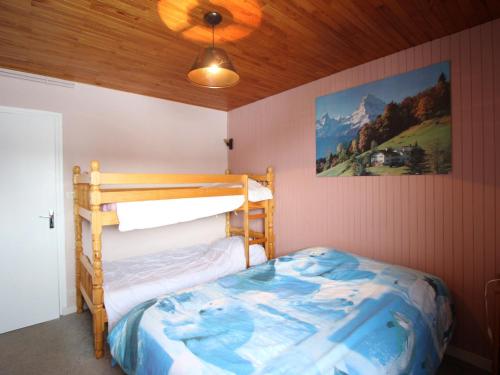 a bedroom with a bunk bed and a painting on the wall at Appartement Chamrousse, 2 pièces, 6 personnes - FR-1-340-278 in Chamrousse