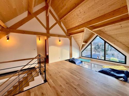 Cette chambre mansardée dispose d'un escalier et d'une grande fenêtre. dans l'établissement Chalet 5 pièces, garage, terrasse, 8 pers - FR-1-608-263, à Le Mont-Dore