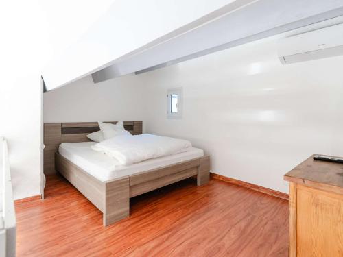 Cette chambre comprend un lit avec des draps blancs et du parquet. dans l'établissement Charmant Pavillon Climatisé avec Mezzanine, Piscine et Parking - Près de la Plage! - FR-1-409-247, à Fleury