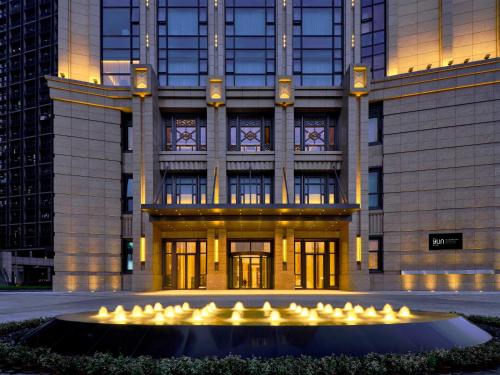 a building with a fountain in front of it at The Yun Hotel Foshan Nanhai in Foshan