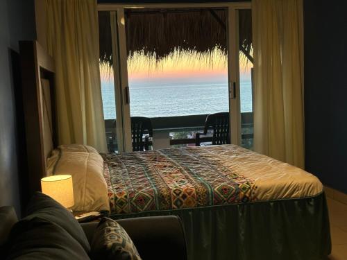 a bedroom with a bed and a view of the ocean at Brisa del Mar #2 in Brisas de Zicatela