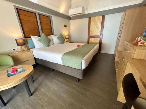 a hotel room with a bed and a table at Serenity Island Resort in Mamanuca Islands