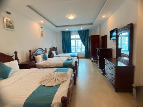 ein Hotelzimmer mit 3 Betten und einem TV in der Unterkunft THIÊN SANG HOTEL in Xuan An