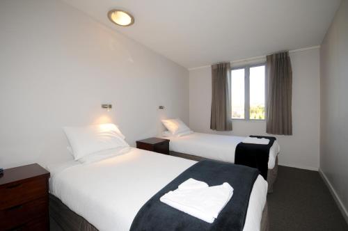 a hotel room with two beds and a window at City Central Motel Apartments in Christchurch