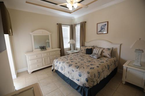 una camera da letto con un letto, un comò e uno specchio di Heated Pool house a Rotunda-West