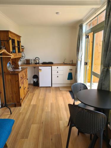 eine Küche mit einem Tisch und Stühlen im Zimmer in der Unterkunft Franvannah Cabin in Waihi