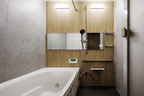 a bathroom with a bath tub and a mirror at Hotel Dios - Vacation STAY 31424v in Awaji