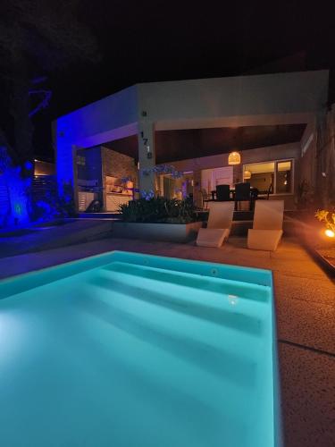 una piscina frente a una casa por la noche en Casa Boutique LUNA LUCIA en Monte Hermoso