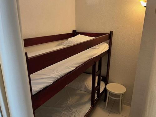 - 2 lits superposés dans une petite chambre avec un tabouret dans l'établissement Appartement T2 cabine - Proche plage, commerces et piscine sécurisée - FR-1-749-35, au Cap d'Agde