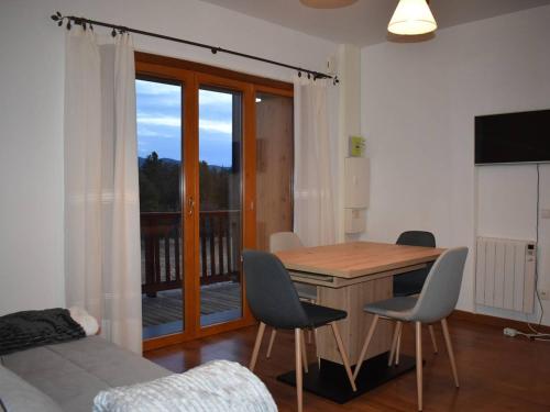 Cette chambre dispose d'une table, de chaises et d'un balcon. dans l'établissement Appartement 3P modernes avec balcon au calme - Font-Romeu - FR-1-580-106, à Font-Romeu-Odeillo-Via