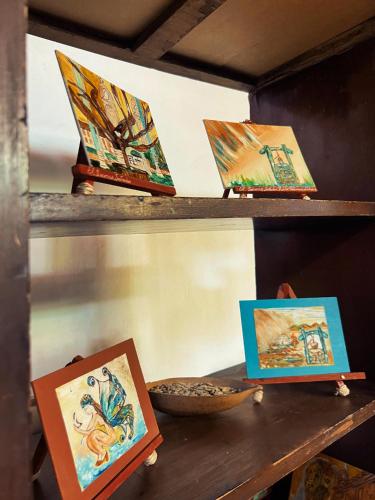 a shelf with paintings on it with a bowl on it at Hotel Casa Solárium Posada in Socorro