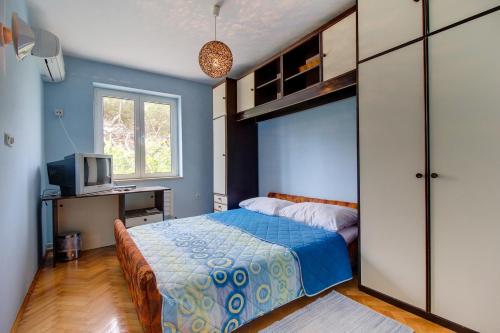 a bedroom with a bed and a desk and a television at Apartment Mario in Mali Lošinj