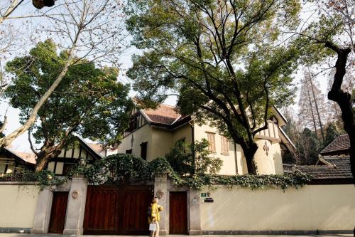 a woman standing in front of a house at Shanghai Downtown Flower B&B - West Fuxing Road Branch in Shanghai