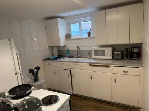 a kitchen with white cabinets and a white stove top oven at Roomy Oasis DC area pet friendly in Takoma Park