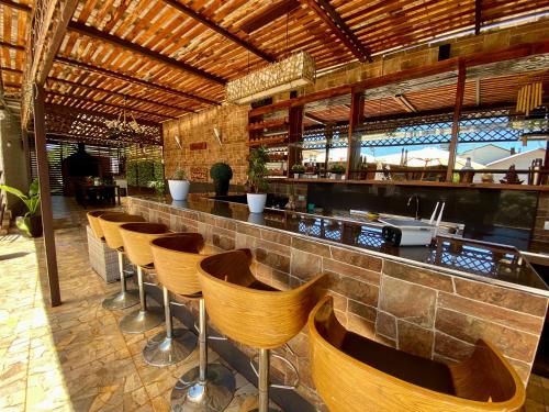 a bar with a row of chairs in a restaurant at Alojamiento RBOY Las Mariposas in Chillán