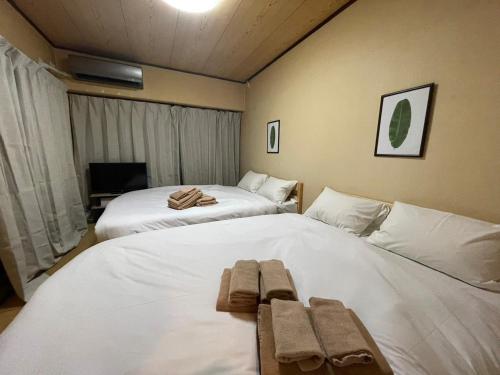 Dos camas en una habitación con toallas. en Sunny Heights Osaki - Vacation STAY 14998, en Tokio