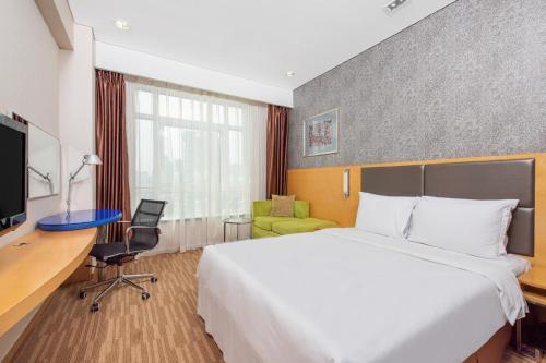 ein Hotelzimmer mit einem Bett und einem Schreibtisch in der Unterkunft Holiday Inn Express Beijing Dongzhimen, an IHG Hotel in Peking