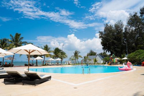 a pool at a resort with chairs and umbrellas at Palace Long Hai Resort & Spa in Long Hai
