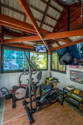 a room with a gym with a bike and a treadmill at Penthouse Crystal Bay Apartments in Ban Lamai