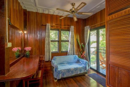 a living room with a chair and a ceiling fan at Penthouse Crystal Bay Apartments in Ban Lamai
