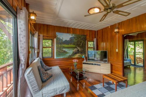 a living room with a couch and a tv at Penthouse Crystal Bay Apartments in Ban Lamai