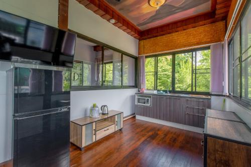 a large kitchen with wooden floors and windows at Penthouse Crystal Bay Apartments in Ban Lamai