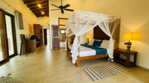 a bedroom with a bed with a canopy at Sea Star Boutique Hotel in Hikkaduwa