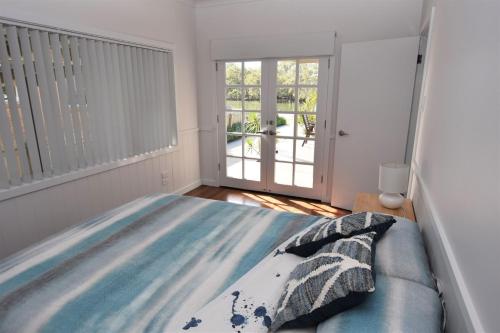 a bedroom with a bed and a large window at Tranquil Waters in Dunbogan