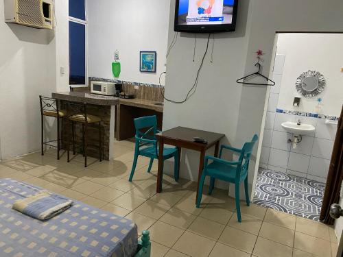 Habitación con mesa, sillas y lavabo. en Playa Malecón, suites y Apart’s en Manta