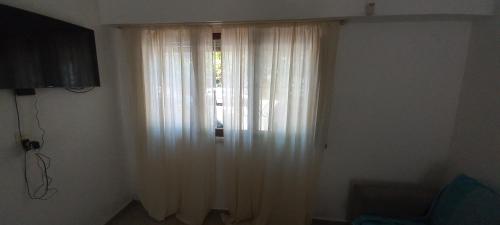 una ventana con cortinas blancas en una habitación en Chauvin House en Mar del Plata