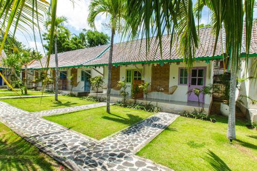 een huis met palmbomen ervoor bij La Roja Bungalows in Nusa Penida