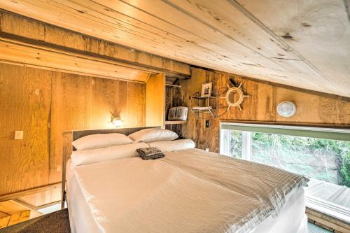 Un dormitorio con una cama en una habitación con paredes de madera. en Serene Seldovia Cabin, en Seldovia